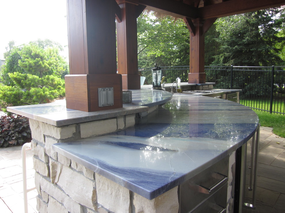 Large elegant backyard stone patio kitchen photo in Minneapolis with a gazebo