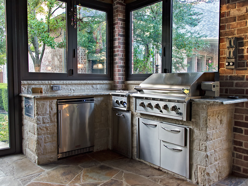 Patio kitchen - mid-sized craftsman backyard stone patio kitchen idea in Dallas with a roof extension