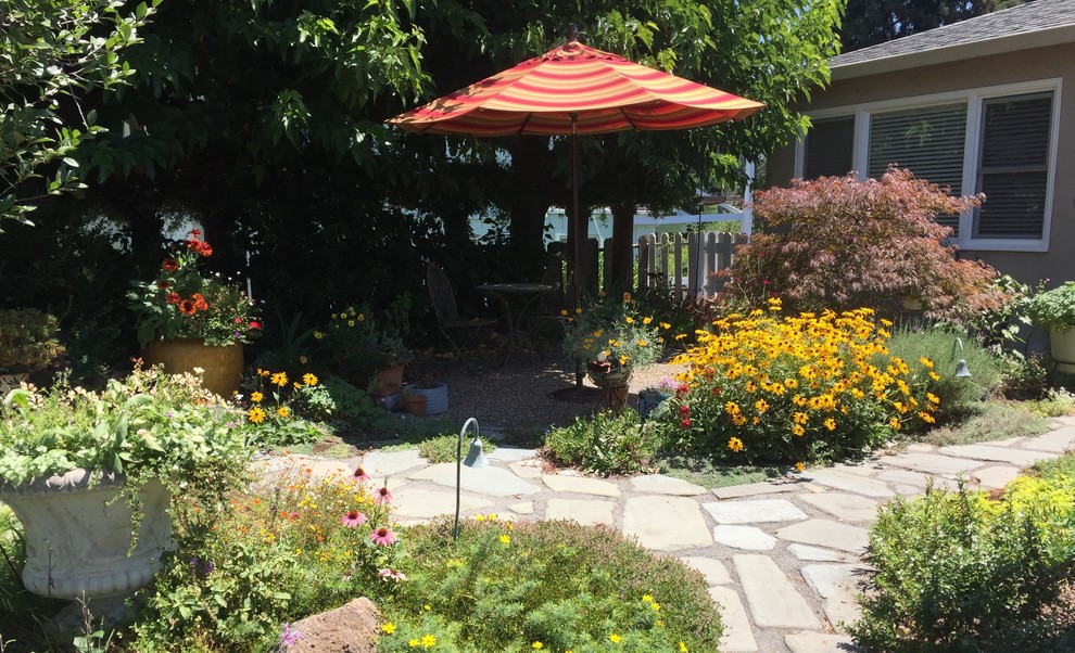 Diseño de patio bohemio de tamaño medio sin cubierta en patio con jardín de macetas y adoquines de piedra natural