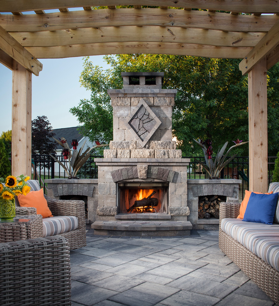 Inspiration for a mid-sized timeless backyard stone patio remodel in New York with a pergola and a fireplace