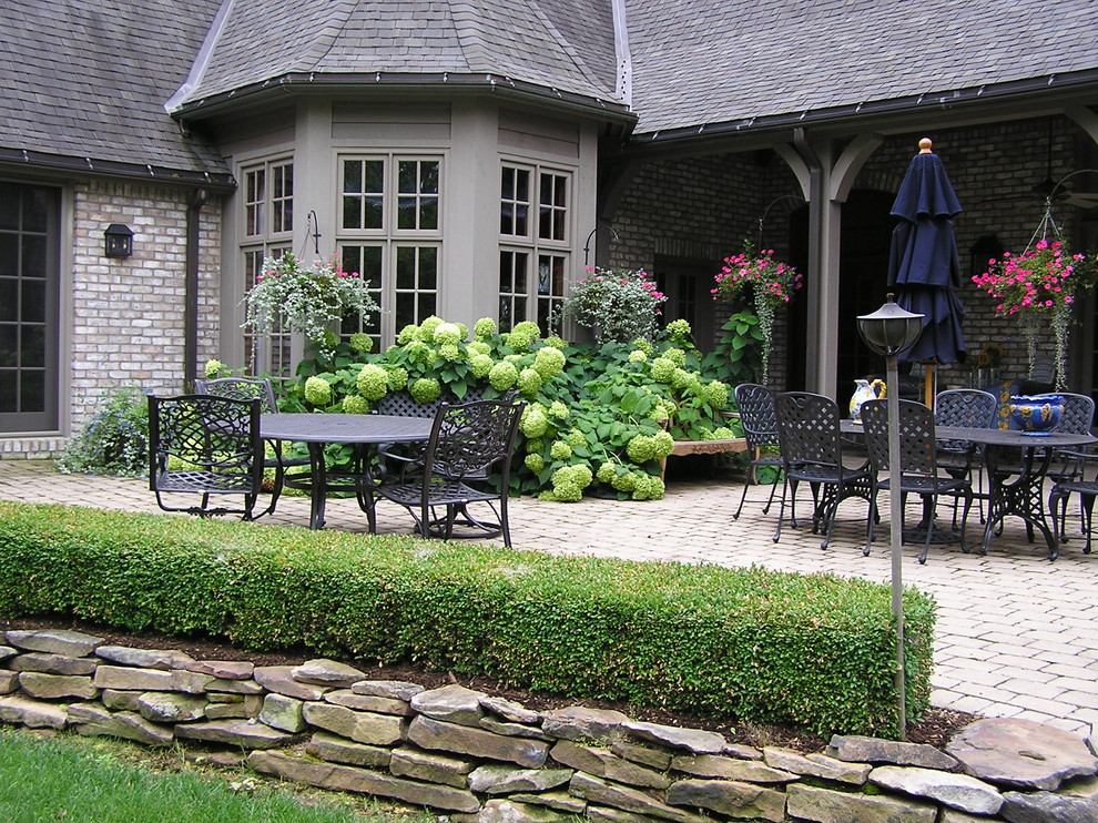 На фото: двор среднего размера на заднем дворе в классическом стиле с мощением клинкерной брусчаткой с