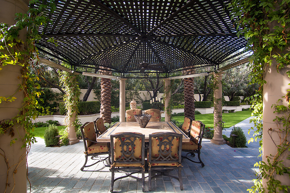 Foto di un grande patio o portico mediterraneo dietro casa con un focolare e un gazebo o capanno