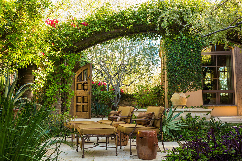 Immagine di un grande patio o portico mediterraneo dietro casa con piastrelle