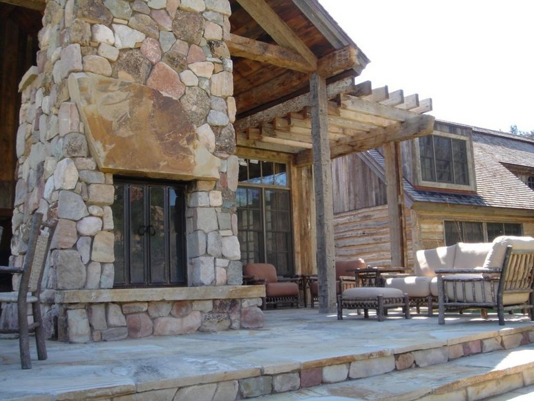 Cette photo montre une grande terrasse arrière montagne avec un foyer extérieur, des pavés en pierre naturelle et une pergola.