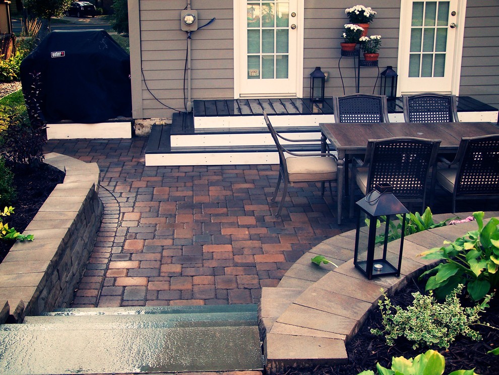 Photo of a small classic back patio in Minneapolis with a potted garden, brick paving and no cover.