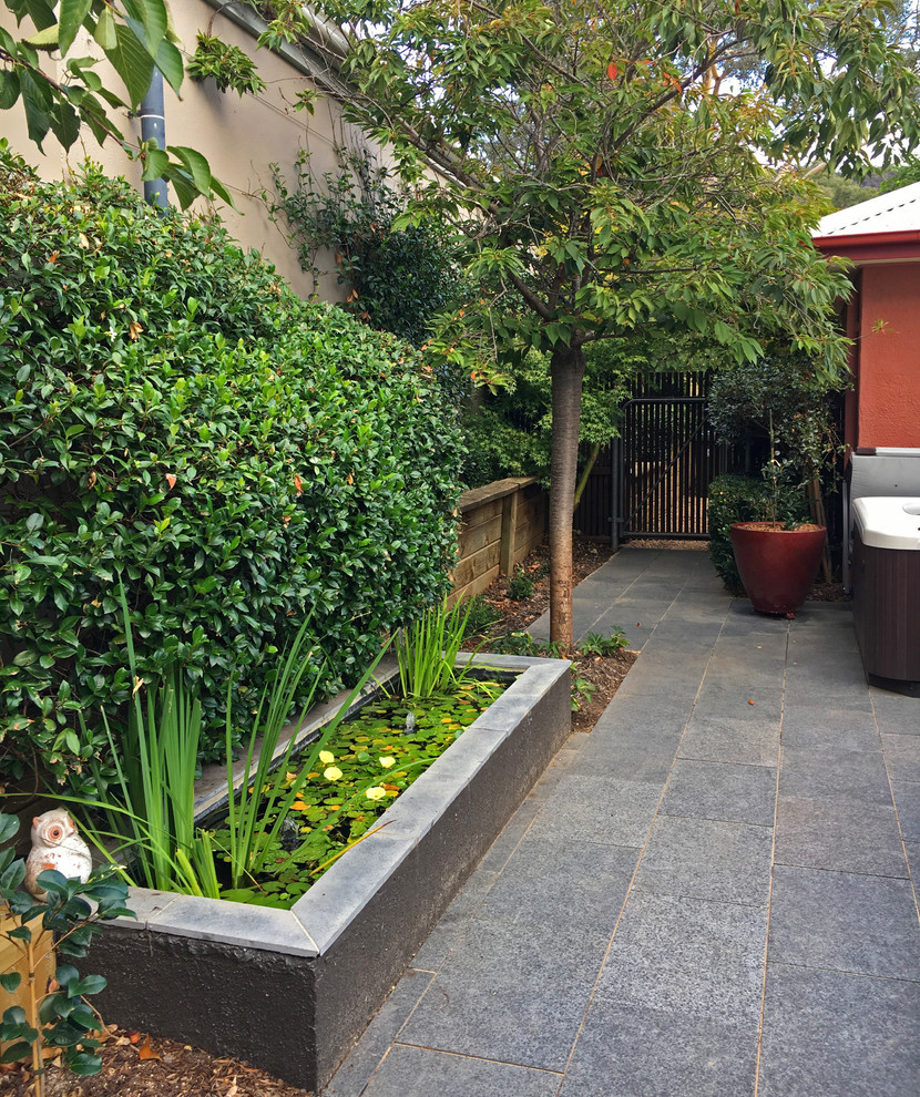 Immagine di un patio o portico design di medie dimensioni e in cortile con fontane, pavimentazioni in pietra naturale e nessuna copertura
