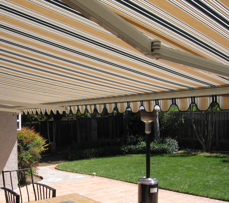 Idee per un grande patio o portico minimalista dietro casa con pavimentazioni in mattoni e un parasole