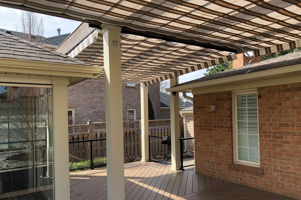 Classic back patio in Toronto with decking and a pergola.