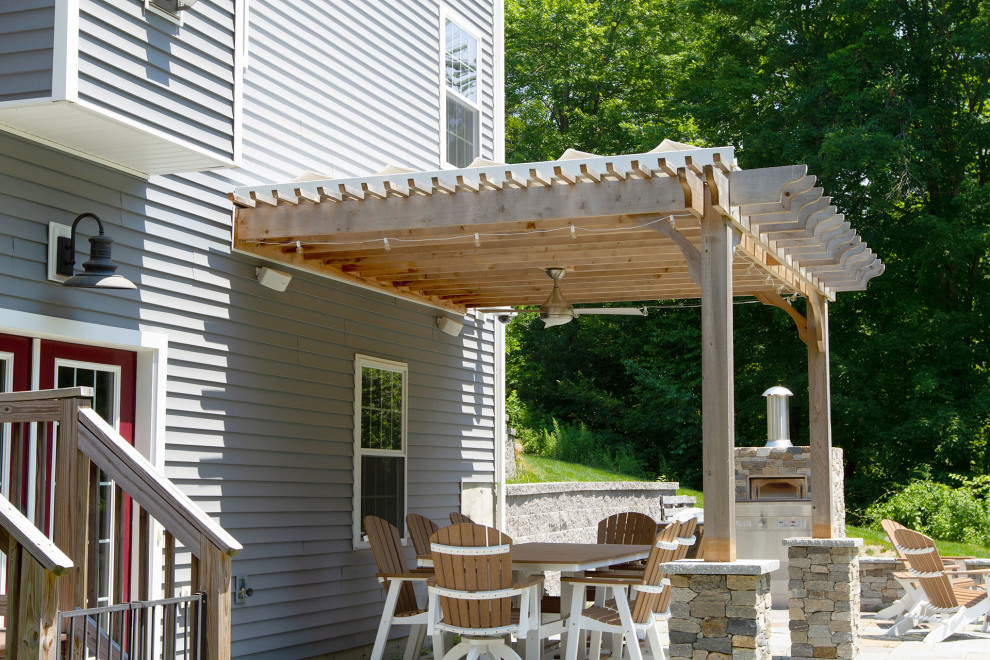 Immagine di un patio o portico stile marino dietro casa con pavimentazioni in cemento e una pergola