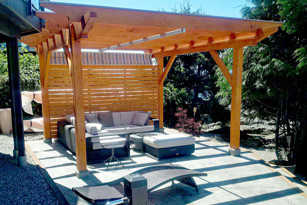 Inspiration for a traditional back patio in Vancouver with a fire feature, concrete paving and a pergola.
