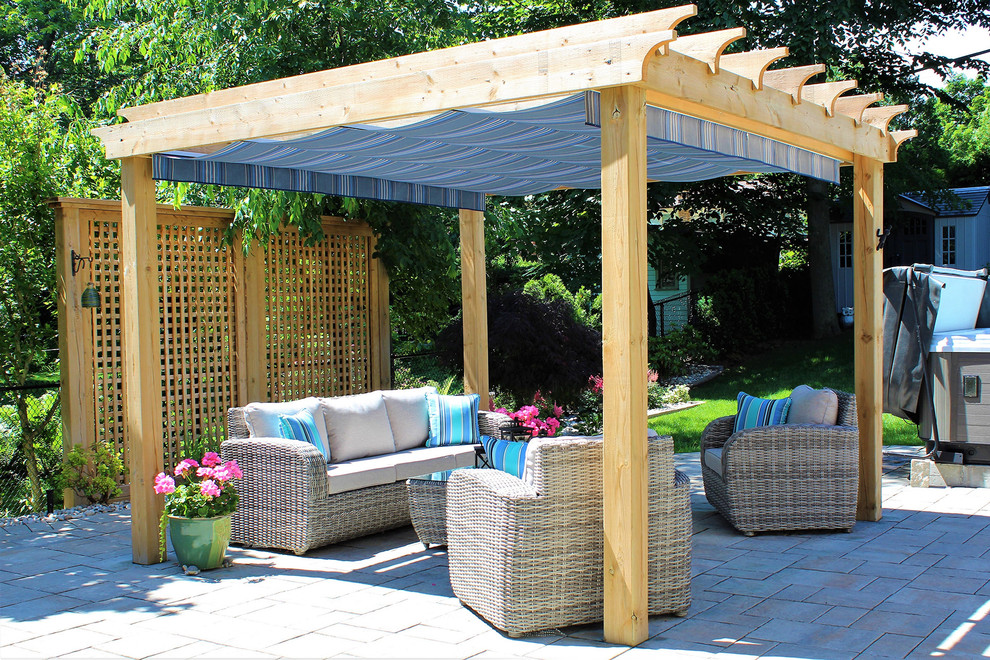 Design ideas for a medium sized world-inspired back patio in Toronto with natural stone paving and a pergola.