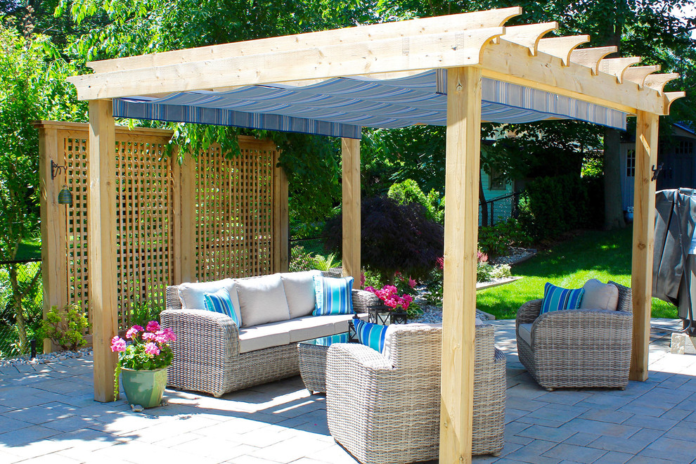 Inspiration for a mid-sized tropical backyard stone patio remodel in Toronto with a pergola