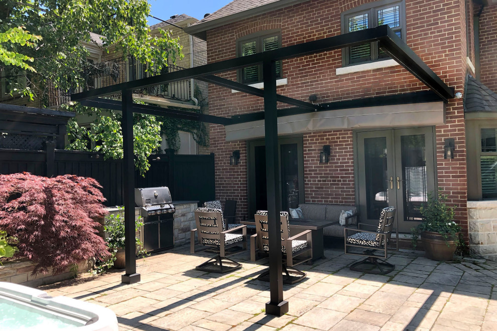 Photo of a modern back patio in Toronto with concrete paving and a pergola.