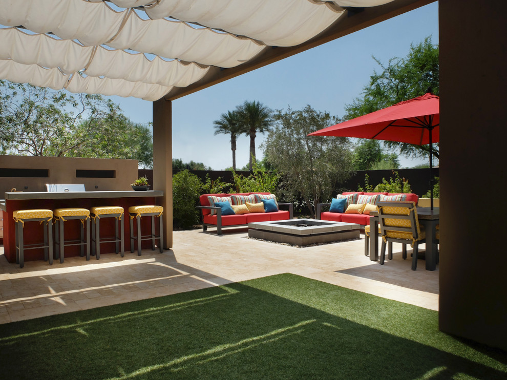 Design ideas for a medium sized contemporary back patio in Phoenix with a water feature, tiled flooring and an awning.