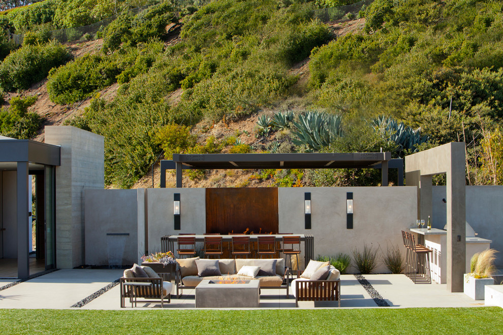Стильный дизайн: огромный двор на заднем дворе в современном стиле с покрытием из бетонных плит и козырьком - последний тренд