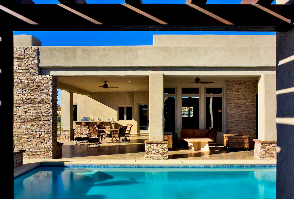 Réalisation d'une terrasse design de taille moyenne avec une cuisine d'été, une cour, une dalle de béton et une extension de toiture.