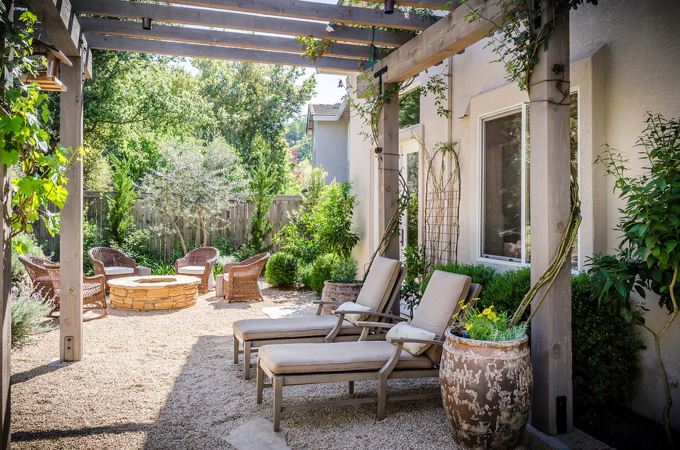 Immagine di un patio o portico mediterraneo dietro casa con graniglia di granito e una pergola