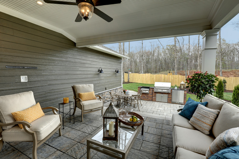 Exemple d'une terrasse chic avec une cuisine d'été et une extension de toiture.