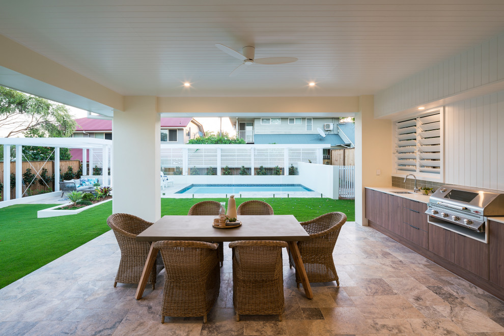 Cette photo montre une grande terrasse tendance avec une cuisine d'été, du carrelage et une extension de toiture.