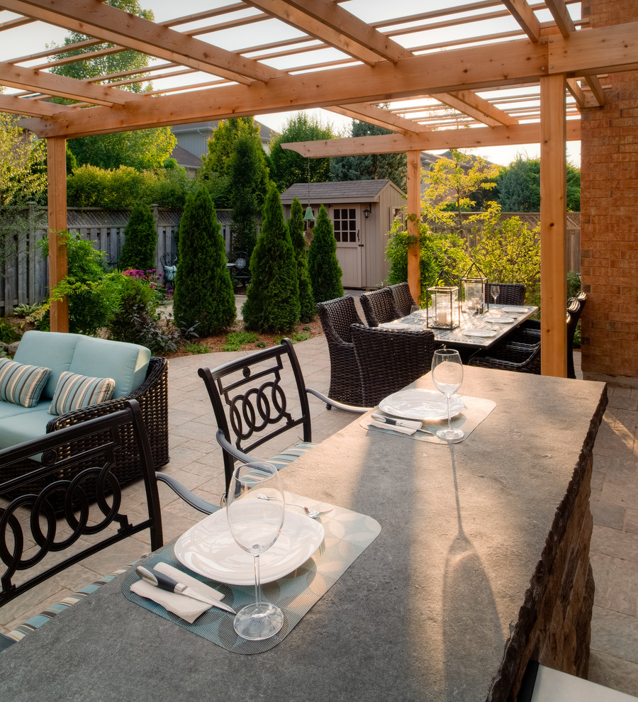 Design ideas for a medium sized rustic back patio in Toronto with a pergola, an outdoor kitchen and natural stone paving.