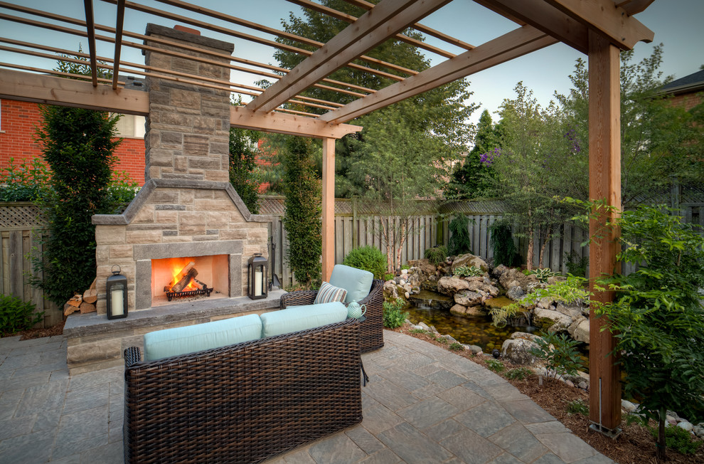 Medium sized contemporary back patio in Toronto with an outdoor kitchen, natural stone paving and no cover.