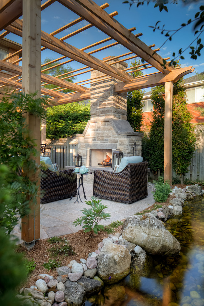 This is an example of a medium sized rustic back patio in Toronto with an outdoor kitchen, natural stone paving and a gazebo.