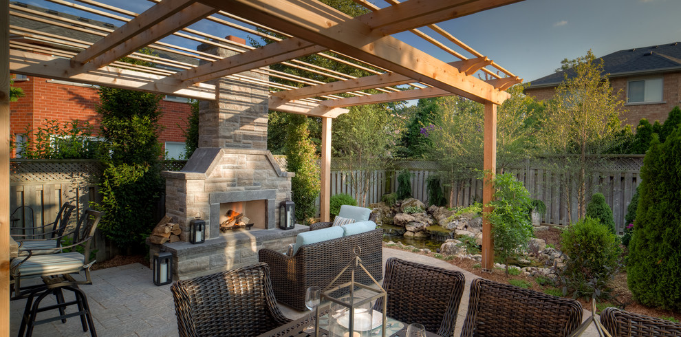 Inspiration pour une terrasse arrière chalet de taille moyenne avec une cuisine d'été, des pavés en pierre naturelle et une pergola.