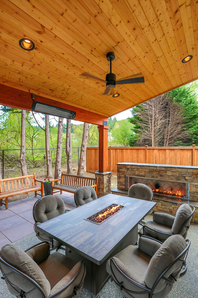 Inspiration for a medium sized classic back patio in Seattle with a fireplace, concrete paving and a roof extension.