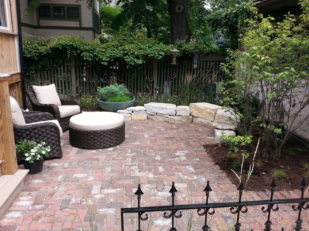 Mid-sized elegant backyard brick patio container garden photo in Chicago with no cover