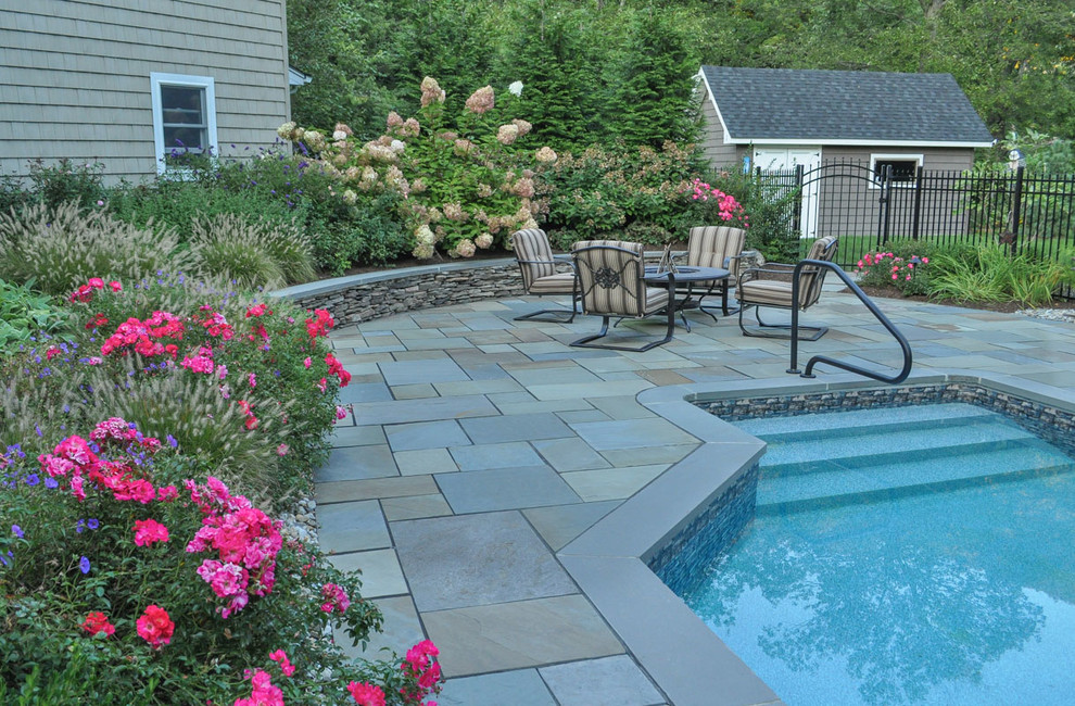 Example of a classic backyard stone patio design in New York