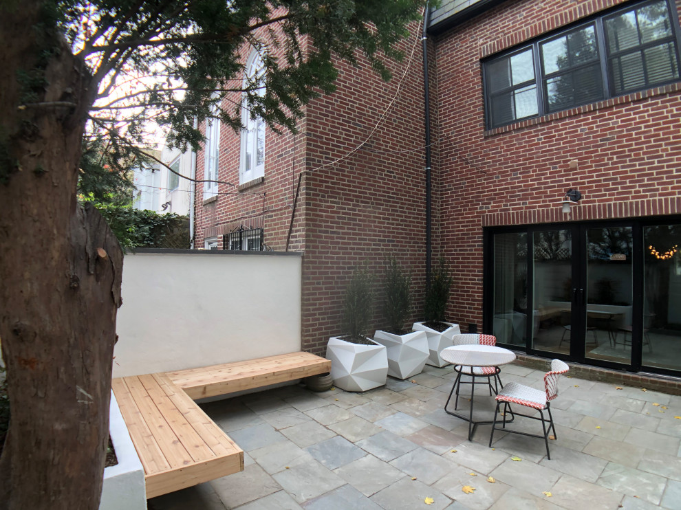Immagine di un piccolo patio o portico minimalista in cortile con pavimentazioni in pietra naturale