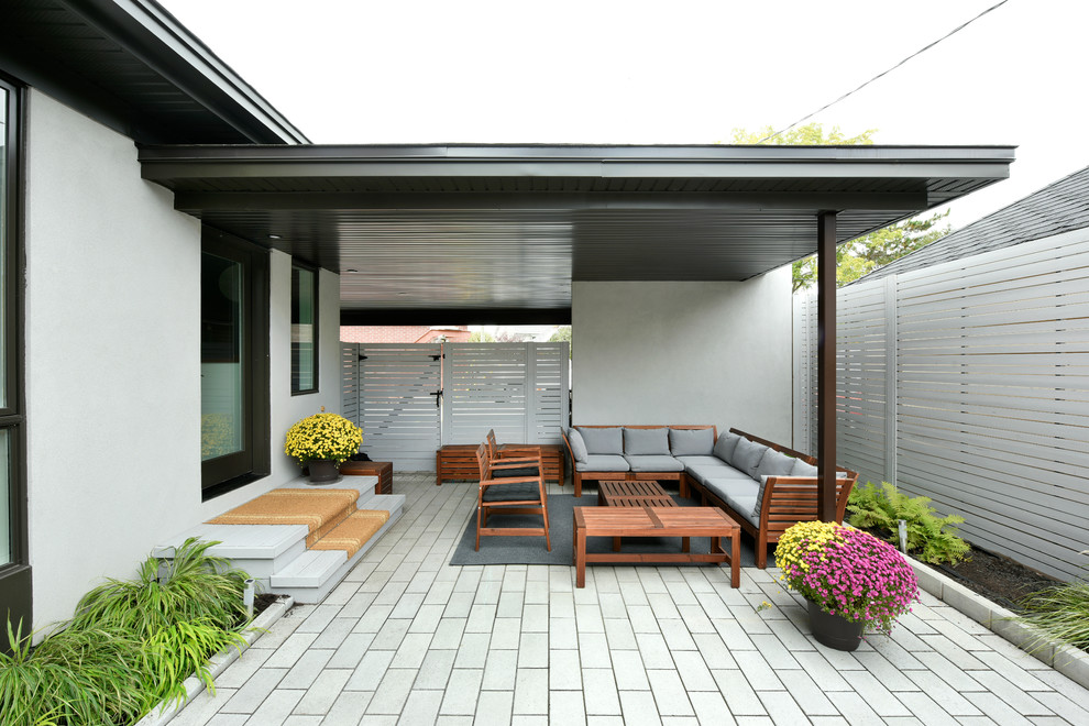 Esempio di un patio o portico design dietro casa con un tetto a sbalzo