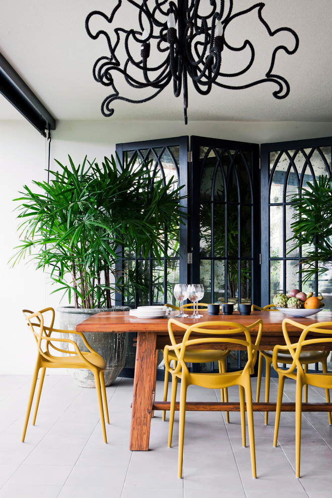 Ispirazione per un patio o portico tropicale dietro casa con un tetto a sbalzo