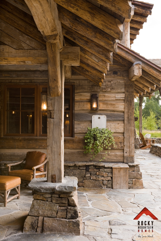 Ispirazione per un patio o portico rustico di medie dimensioni e nel cortile laterale con pavimentazioni in pietra naturale e un tetto a sbalzo