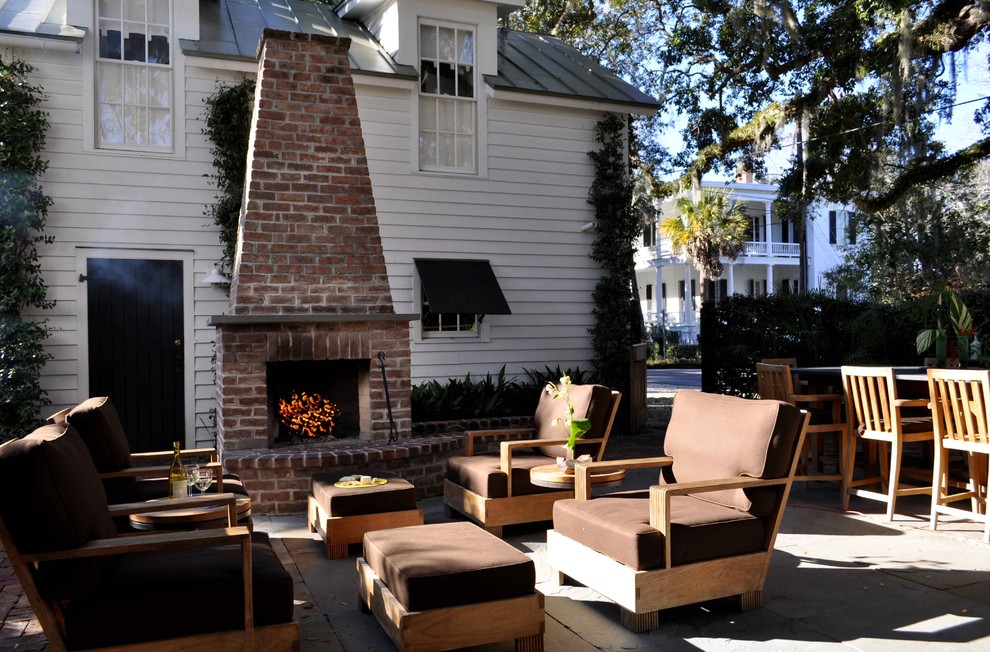 Idée de décoration pour une terrasse arrière tradition de taille moyenne avec un foyer extérieur, des pavés en pierre naturelle et aucune couverture.