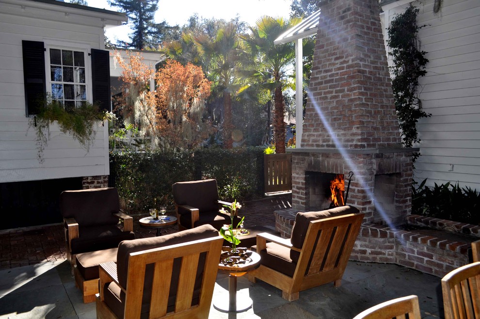 This is an example of a medium sized classic back patio in Atlanta with a fire feature, natural stone paving and no cover.