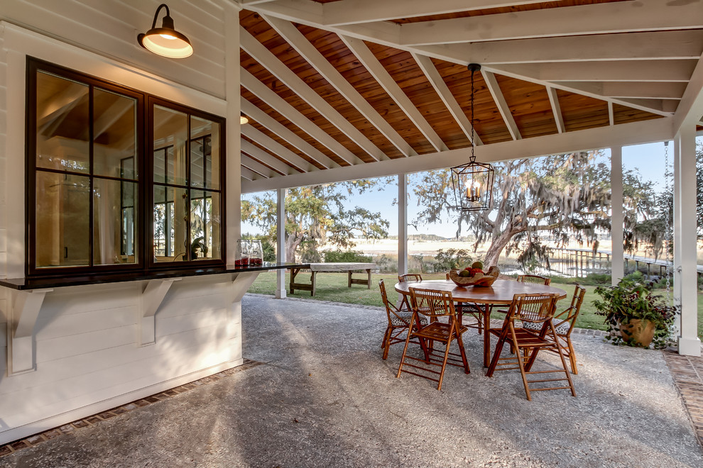 Foto di un patio o portico minimal di medie dimensioni e dietro casa con un caminetto, lastre di cemento e un tetto a sbalzo