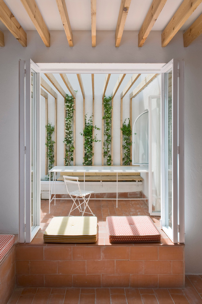 Small scandinavian back patio in Barcelona with a pergola and tiled flooring.
