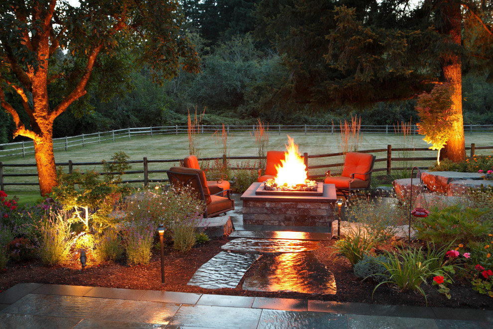 Inspiration for a large 1960s backyard stone patio remodel in Seattle with a fire pit