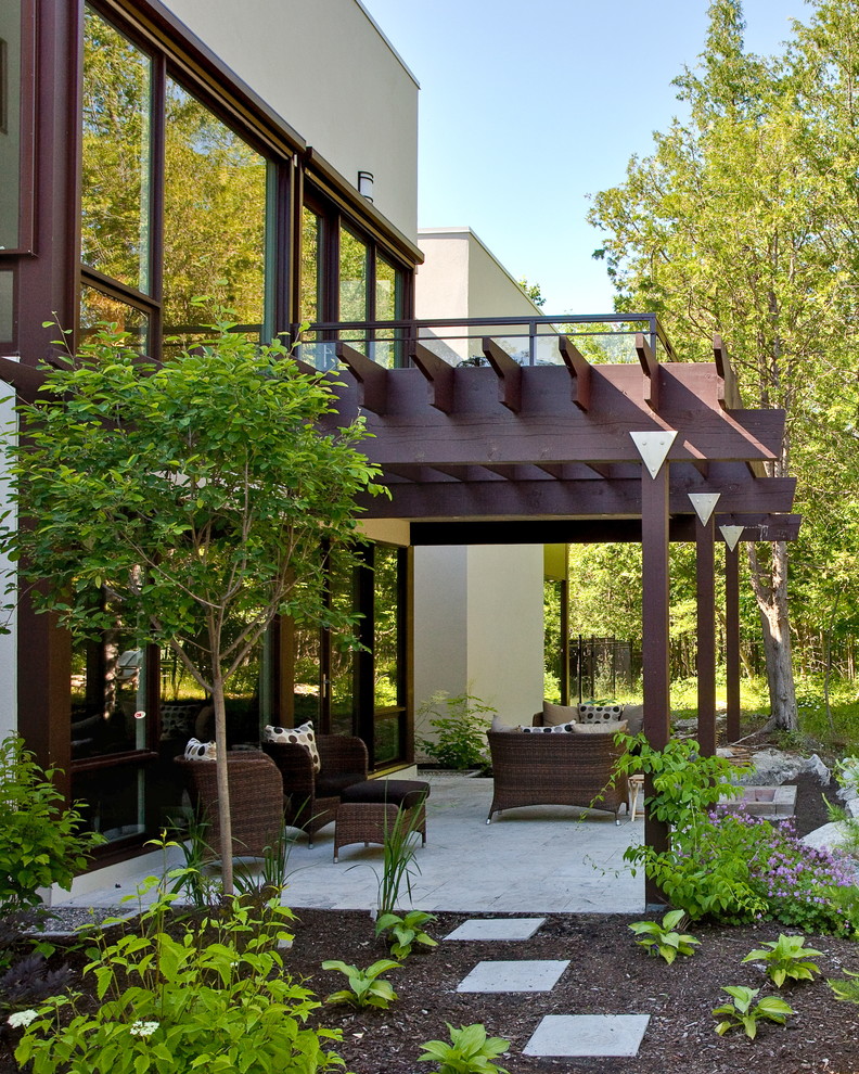 Ejemplo de patio minimalista en patio lateral con adoquines de piedra natural y pérgola