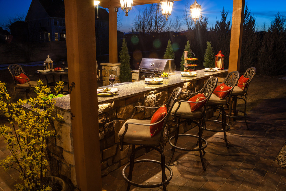 Large elegant backyard concrete paver patio kitchen photo in Denver with a pergola