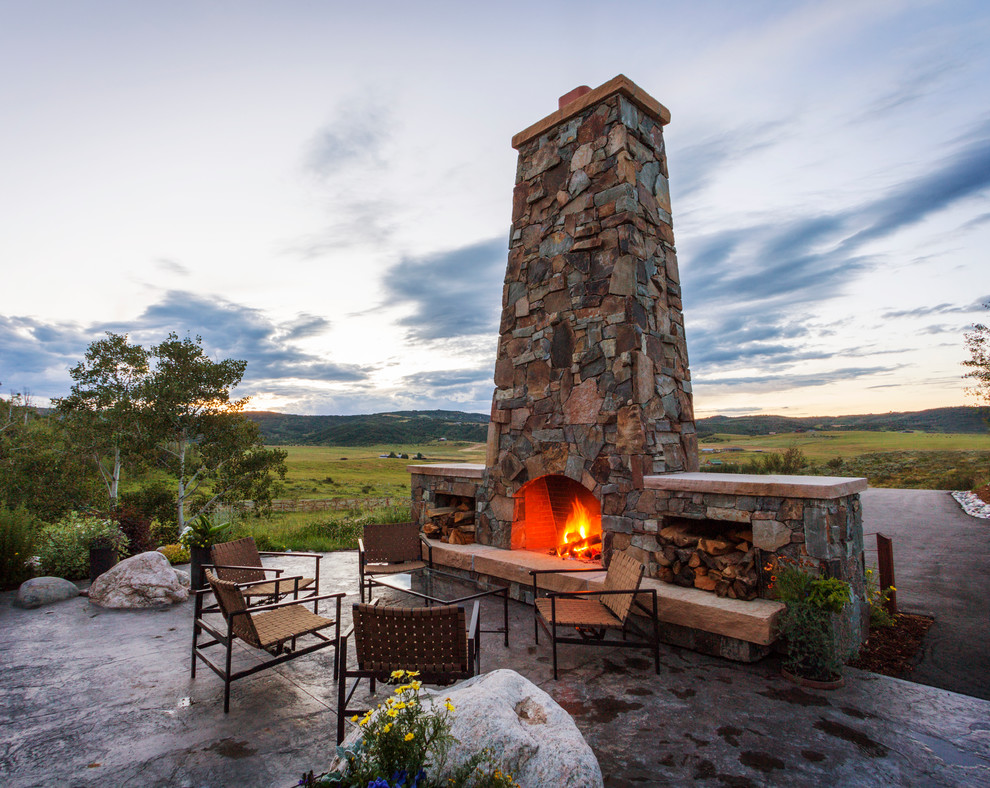 Design ideas for a rustic patio in Denver with stamped concrete, no cover and a fireplace.