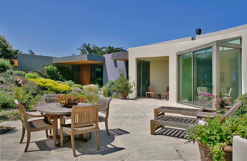 На фото: двор в современном стиле с покрытием из каменной брусчатки без защиты от солнца с