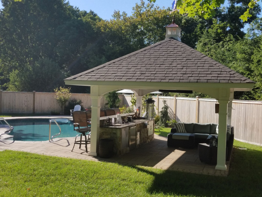 Photo of a large traditional back patio in Philadelphia with an outdoor kitchen, a gazebo and natural stone paving.