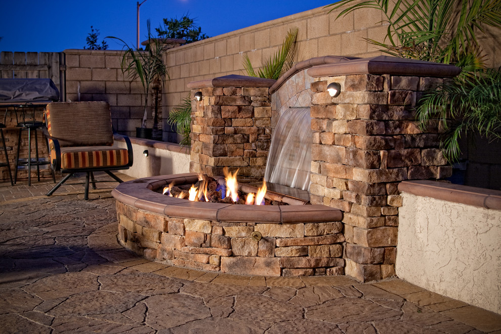 Example of a mid-sized mountain style backyard concrete paver patio design in San Diego with a fire pit
