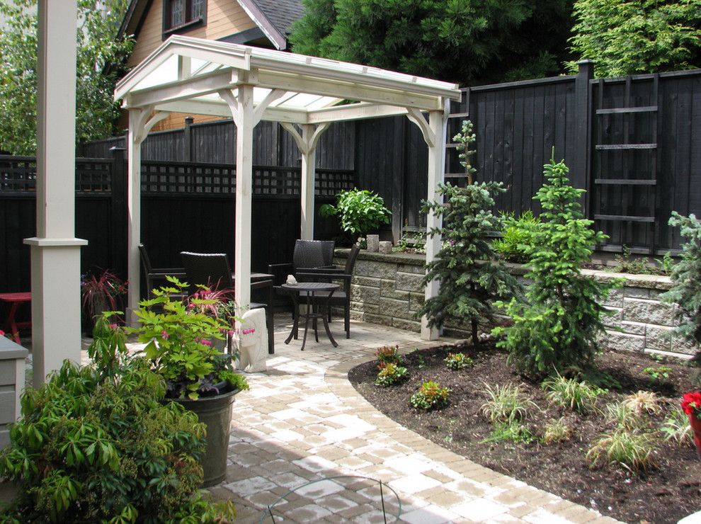 Immagine di un piccolo patio o portico tradizionale dietro casa con un giardino in vaso, pavimentazioni in cemento e una pergola