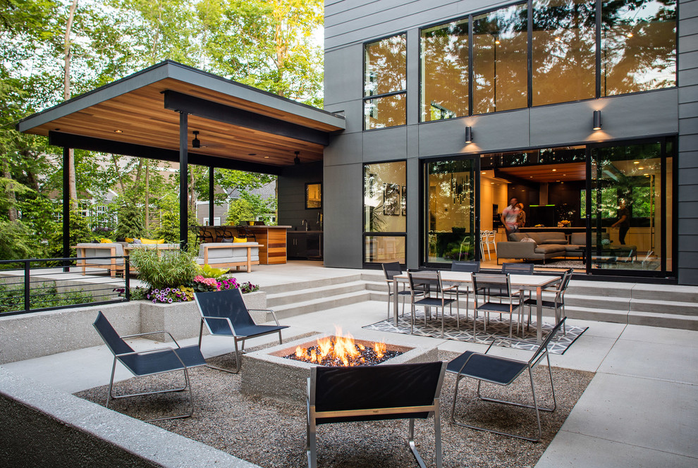Inspiration for a contemporary concrete paver patio remodel in Grand Rapids with a fire pit and no cover