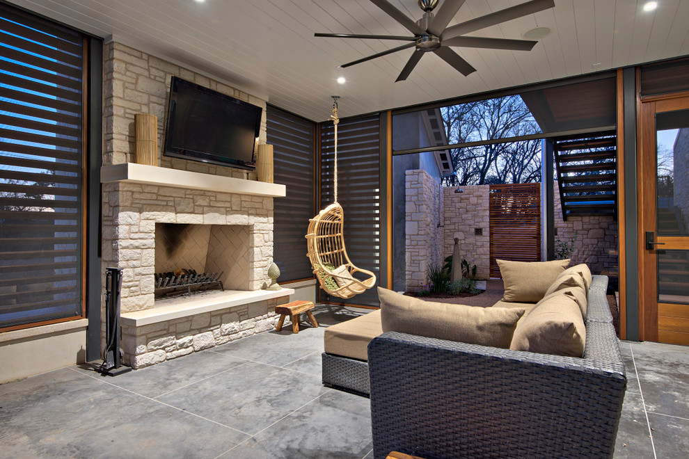 Foto di un grande patio o portico classico dietro casa con lastre di cemento, un tetto a sbalzo e un caminetto