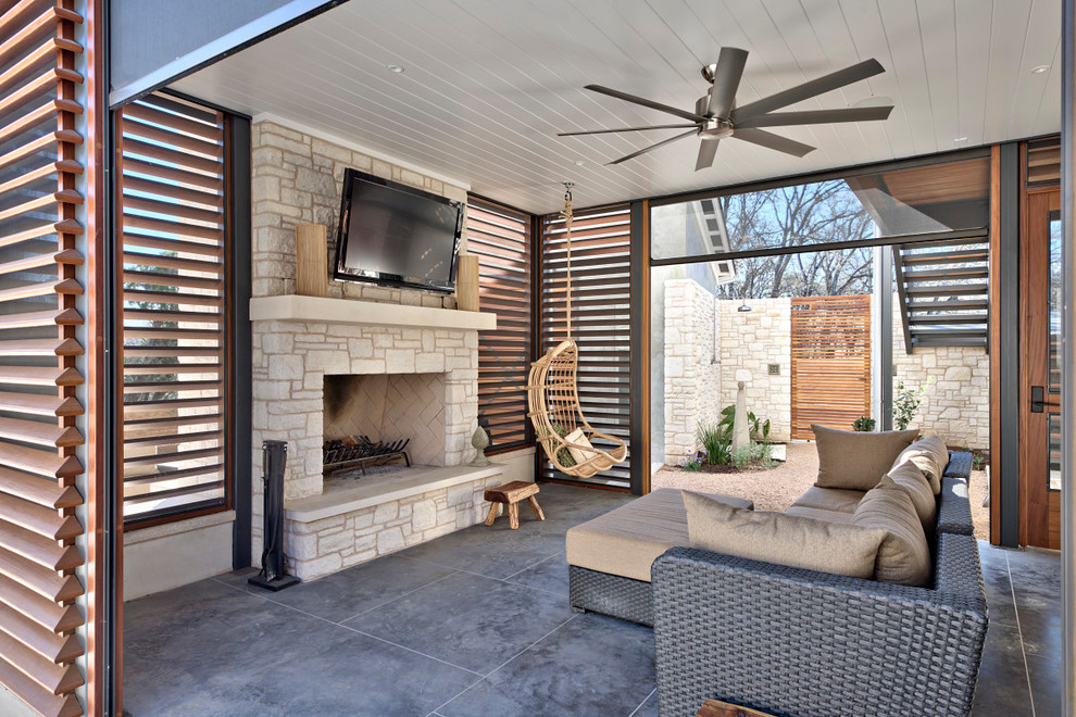 Idee per un grande patio o portico tradizionale dietro casa con lastre di cemento, un tetto a sbalzo e un caminetto