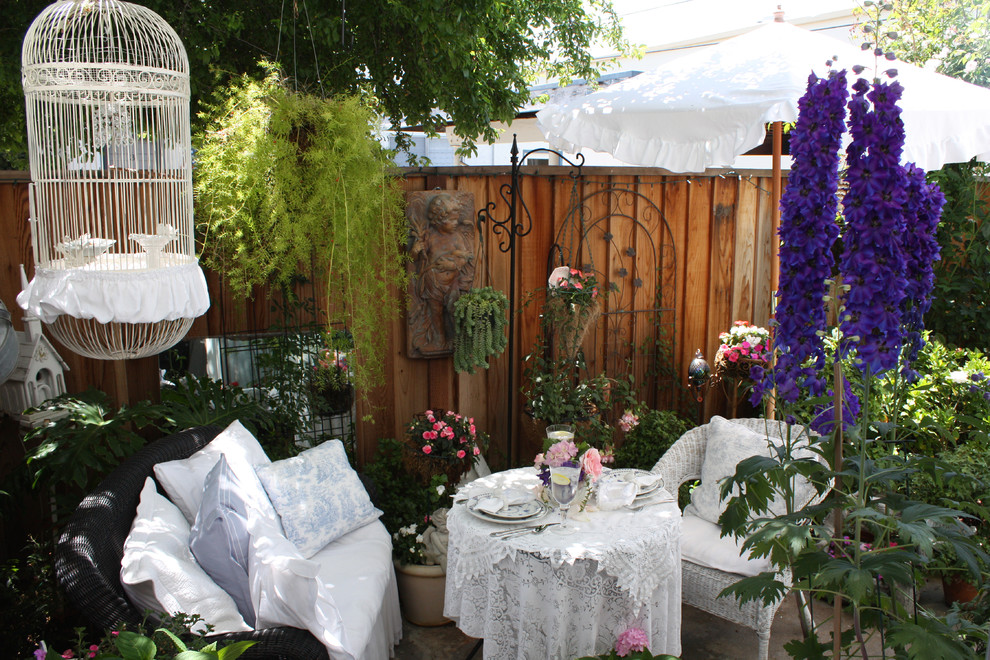 Cette photo montre une terrasse avec des plantes en pots romantique.